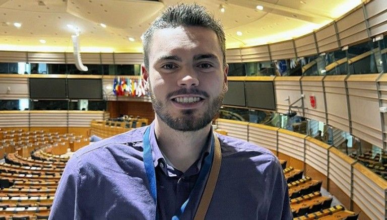 male student posing in an auditorium