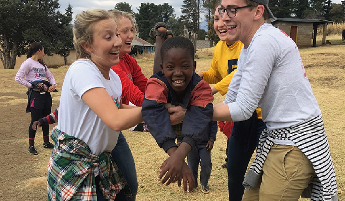 Students playing with orphans in Lesotho