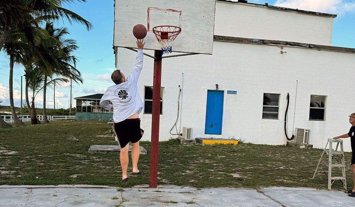 A student shoots a basketball at a hoop